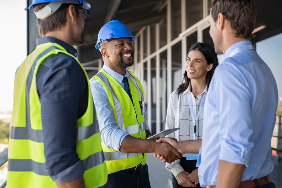 Construction team shaking hands with a client